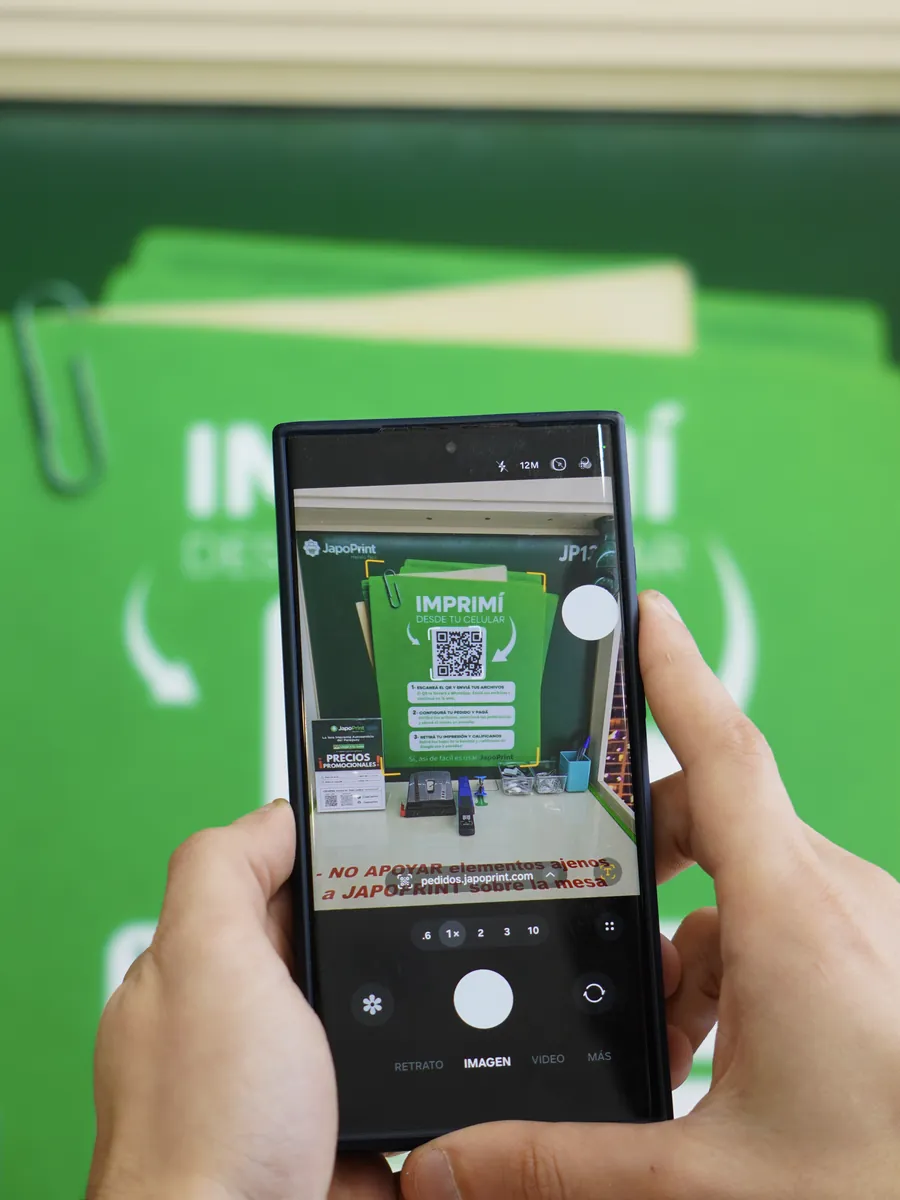 Una mano escanea con el celular el código QR del panel del tótem