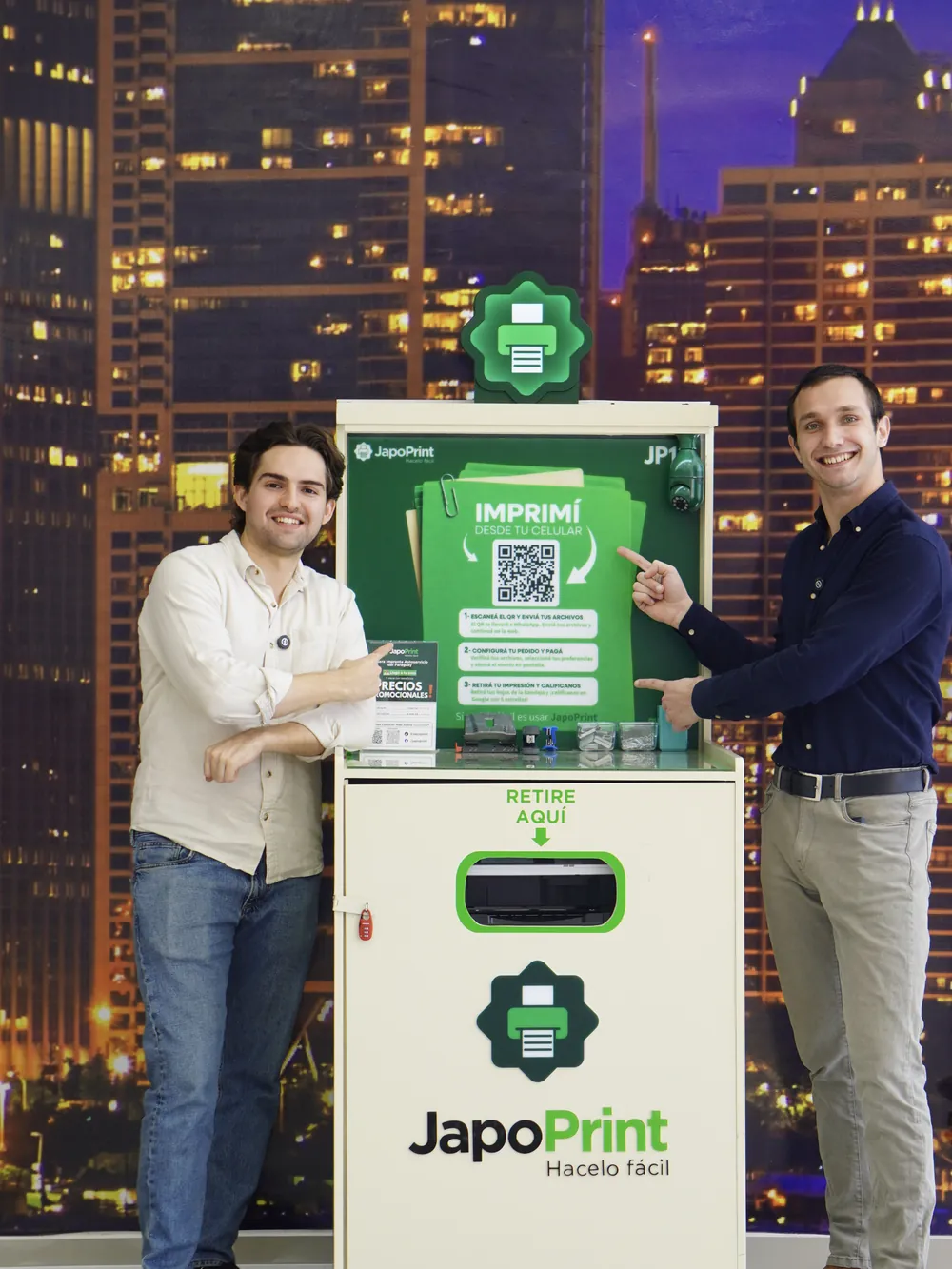 Dos personas junto a un tótem JapoPrint instalado en un local